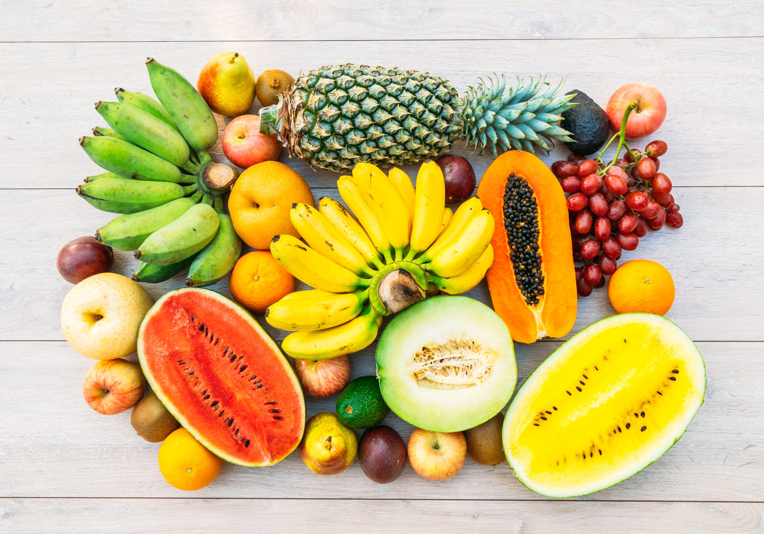 Mixed fruits with apple banana orange and other on wooden background - Healthy food style